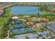 Aerial view of community amenities including a pool, tennis courts, and a lake at 5011 Tivoli Run, Bradenton, FL 34211