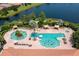 Aerial view of a resort-style pool with a poolside island, cabanas, and lake views at 5011 Tivoli Run, Bradenton, FL 34211