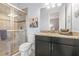 Modern bathroom featuring a granite countertop, dark cabinets, and a glass shower enclosure at 5011 Tivoli Run, Bradenton, FL 34211