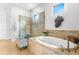 Luxurious bathroom with soaking tub, glass shower, and decorative tile accents at 5011 Tivoli Run, Bradenton, FL 34211