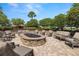 Outdoor seating area with comfortable patio furniture centered around a cozy stone fire pit at 5011 Tivoli Run, Bradenton, FL 34211