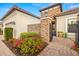 Elegant entryway featuring a stone accent wall, brick walkway, and colorful flower beds at 5011 Tivoli Run, Bradenton, FL 34211