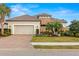 Charming home showcasing a manicured front yard and brick-paved driveway at 5011 Tivoli Run, Bradenton, FL 34211