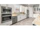 Modern kitchen featuring built-in stainless appliances, tile backsplash, and light-colored cabinetry for a clean aesthetic at 5011 Tivoli Run, Bradenton, FL 34211