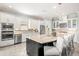 Open-concept kitchen boasts a central island, stainless appliances, and sleek white cabinetry for a modern design at 5011 Tivoli Run, Bradenton, FL 34211