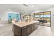 Modern kitchen with spacious island, pendant lighting, and an open layout to a living space with lots of natural light at 5011 Tivoli Run, Bradenton, FL 34211