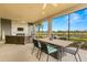 Spacious covered patio featuring an outdoor dining area with views of a peaceful lake at 5011 Tivoli Run, Bradenton, FL 34211