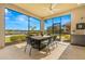 Screened-in patio with a dining table and a bar area overlooking a beautiful lake at 5011 Tivoli Run, Bradenton, FL 34211