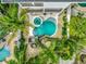 An aerial view of a backyard with a pool, a hot tub, landscaping, and palm trees at 5219 Calle Menorca, Sarasota, FL 34242