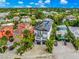 Lovely aerial view of this two-story home with a rooftop pool and beautifully landscaped yard, nestled within lush greenery at 5219 Calle Menorca, Sarasota, FL 34242