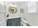 Cozy bathroom with a stylish round mirror, granite vanity and a modern toilet at 5219 Calle Menorca, Sarasota, FL 34242