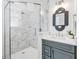 Bathroom featuring a glass shower, marble tiling, decorative mirror, and stylish vanity at 5219 Calle Menorca, Sarasota, FL 34242