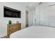 Bright bedroom features a wall-mounted TV, wood dresser, and closet with white sliding doors at 5219 Calle Menorca, Sarasota, FL 34242
