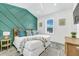 Bright bedroom with white walls, a modern accent wall, and a plush bed with decorative pillows at 5219 Calle Menorca, Sarasota, FL 34242