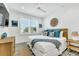 Bright bedroom with shiplap accent wall, ceiling fan, decorative mirror, and queen bed at 5219 Calle Menorca, Sarasota, FL 34242