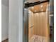 Interior view of the home's elevator with wood paneled walls and flooring at 5219 Calle Menorca, Sarasota, FL 34242