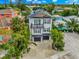Charming two-story home with a black-and-white facade, garage, balcony and a rooftop pool, surrounded by lush greenery at 5219 Calle Menorca, Sarasota, FL 34242