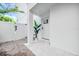 Inviting front entrance with a white door, stone patio, columned porch, and manicured landscaping at 5219 Calle Menorca, Sarasota, FL 34242