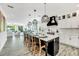Modern eat-in kitchen with center island, stylish pendant lighting and stainless steel appliances at 5219 Calle Menorca, Sarasota, FL 34242