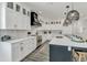 Modern kitchen features white cabinets, stainless appliances, quartz countertops, and center island at 5219 Calle Menorca, Sarasota, FL 34242