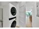 Efficient laundry area with stacked washer and dryer units and view into dinning and living areas at 5219 Calle Menorca, Sarasota, FL 34242