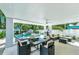 Outdoor patio with a dining table, comfortable seating, and a view of the pool and landscaping at 5219 Calle Menorca, Sarasota, FL 34242