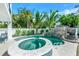 Backyard pool and spa feature tropical landscaping, a rock slide, and a serene, inviting atmosphere at 5219 Calle Menorca, Sarasota, FL 34242