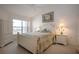 Bright bedroom with tropical bedding, white furniture, and a large window for natural light at 5330 Hyland Hills Ave # 2324, Sarasota, FL 34241