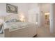 Bright bedroom with tropical bedding, white furniture, a private bath, and large window views at 5330 Hyland Hills Ave # 2324, Sarasota, FL 34241
