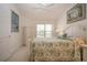Comfortable bedroom showcasing a large window, tropical bedding, and bright, neutral walls at 5330 Hyland Hills Ave # 2324, Sarasota, FL 34241