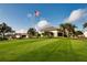 Beautiful clubhouse with manicured lawn and American flag waving in the breeze, embodying community spirit at 5330 Hyland Hills Ave # 2324, Sarasota, FL 34241