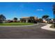 Elegant clubhouse entrance with well-manicured lawns and palm trees at 5330 Hyland Hills Ave # 2324, Sarasota, FL 34241