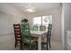 Dining area with a bright white table and colorful wooden chairs and a large window at 5330 Hyland Hills Ave # 2324, Sarasota, FL 34241
