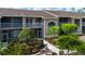 Condo's exterior shows a well-maintained facade with landscaping and a sidewalk leading to the entrance at 5330 Hyland Hills Ave # 2324, Sarasota, FL 34241