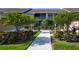 Exterior of a condo building with a central walkway, manicured bushes and trees at 5330 Hyland Hills Ave # 2324, Sarasota, FL 34241