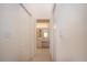 Clean hallway leading to a bright bathroom with a well-lit vanity and closet at 5330 Hyland Hills Ave # 2324, Sarasota, FL 34241