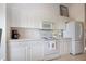 Well-lit kitchen with white cabinets, microwave, and appliances, offering ample storage at 5330 Hyland Hills Ave # 2324, Sarasota, FL 34241