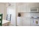 Cozy kitchen area with white cabinets and appliances, adjacent to a dining space at 5330 Hyland Hills Ave # 2324, Sarasota, FL 34241