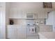 Bright kitchen features white cabinets, countertop appliances and ample storage at 5330 Hyland Hills Ave # 2324, Sarasota, FL 34241