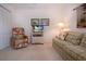 Comfortable living room with a plaid sofa, floral chair, and entertainment center at 5330 Hyland Hills Ave # 2324, Sarasota, FL 34241