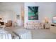 Bright living room with coastal tapestry, cozy seating, and an open concept to kitchen area at 5330 Hyland Hills Ave # 2324, Sarasota, FL 34241