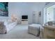 Bright living room with floral sofa, striped ottoman, and access to the outdoor balcony through glass sliding doors at 5330 Hyland Hills Ave # 2324, Sarasota, FL 34241
