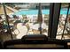 View from inside the gym of the pool with lounge chairs and tables surrounded by trees at 5330 Hyland Hills Ave # 2324, Sarasota, FL 34241