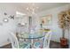 Charming dining area with a glass table, whimsical chandelier, and bright floral chairs at 550 Tampico Dr, North Port, FL 34287