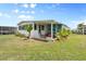 Charming home exterior with a cozy patio area, surrounded by well-kept lawn and vibrant foliage at 550 Tampico Dr, North Port, FL 34287