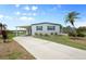 Charming single-story home featuring a covered carport, well-maintained lawn, and mature palm trees at 550 Tampico Dr, North Port, FL 34287