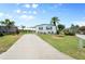 Well-maintained home with a long driveway, landscaped yard, and a covered parking area at 550 Tampico Dr, North Port, FL 34287