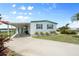 Inviting home exterior with a covered parking area, complemented by manicured landscaping and a view of the water at 550 Tampico Dr, North Port, FL 34287