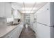 Functional kitchen features white cabinets and appliances, and opens to a dining area at 550 Tampico Dr, North Port, FL 34287