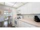 Bright kitchen with white cabinets and appliances, countertop space, and open flow to dining area at 550 Tampico Dr, North Port, FL 34287